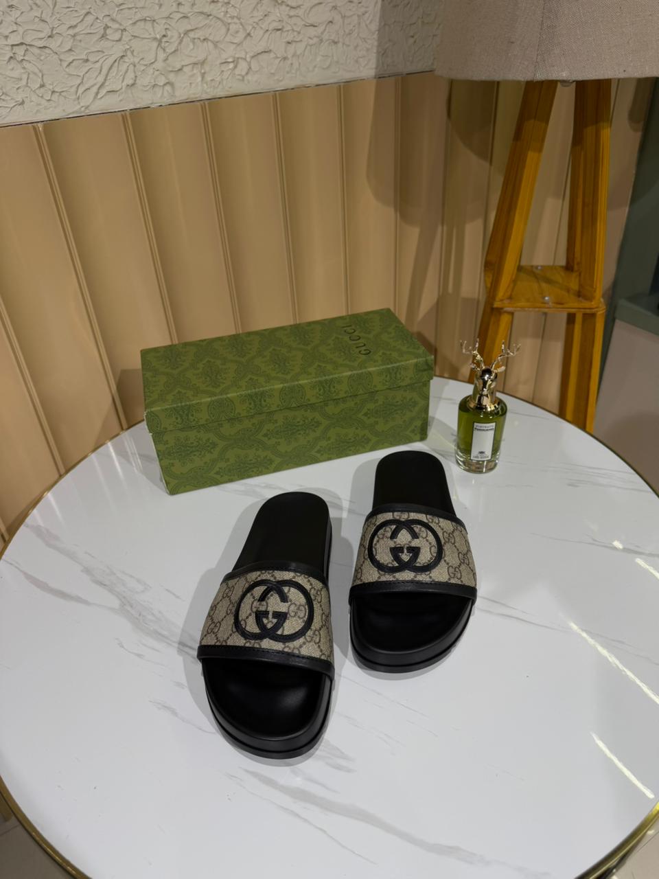 Gucci slides featuring the brand’s iconic GG monogram canvas.